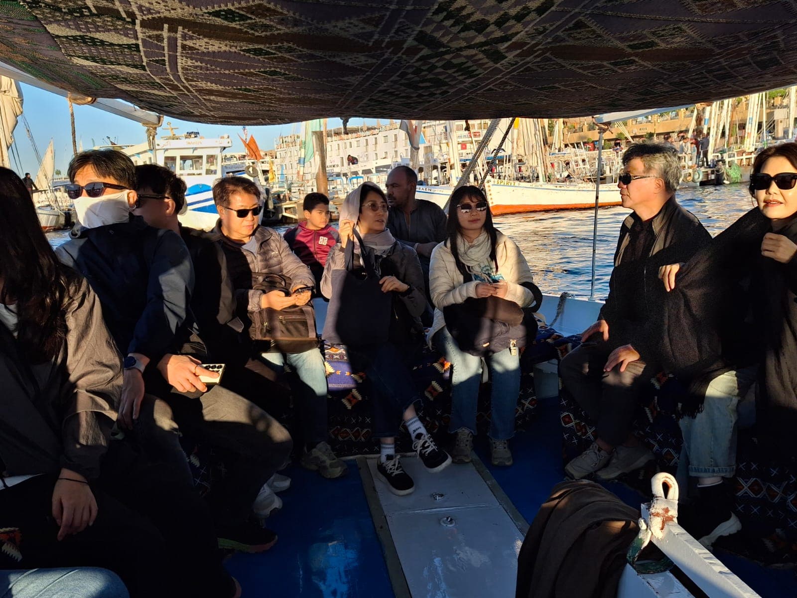 Guests aboard a felucca among the sailing boats on the Nile at Aswan