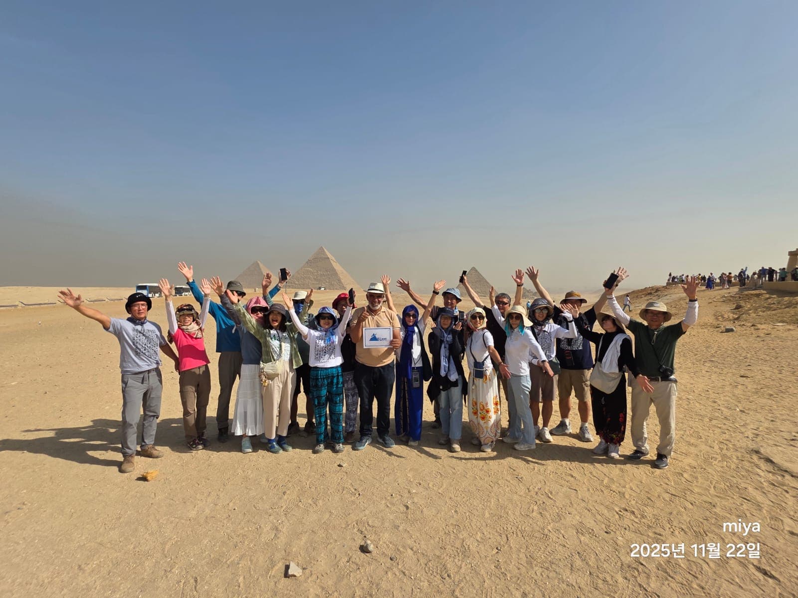 Travel To Egypt tour group celebrating in front of the Giza pyramids