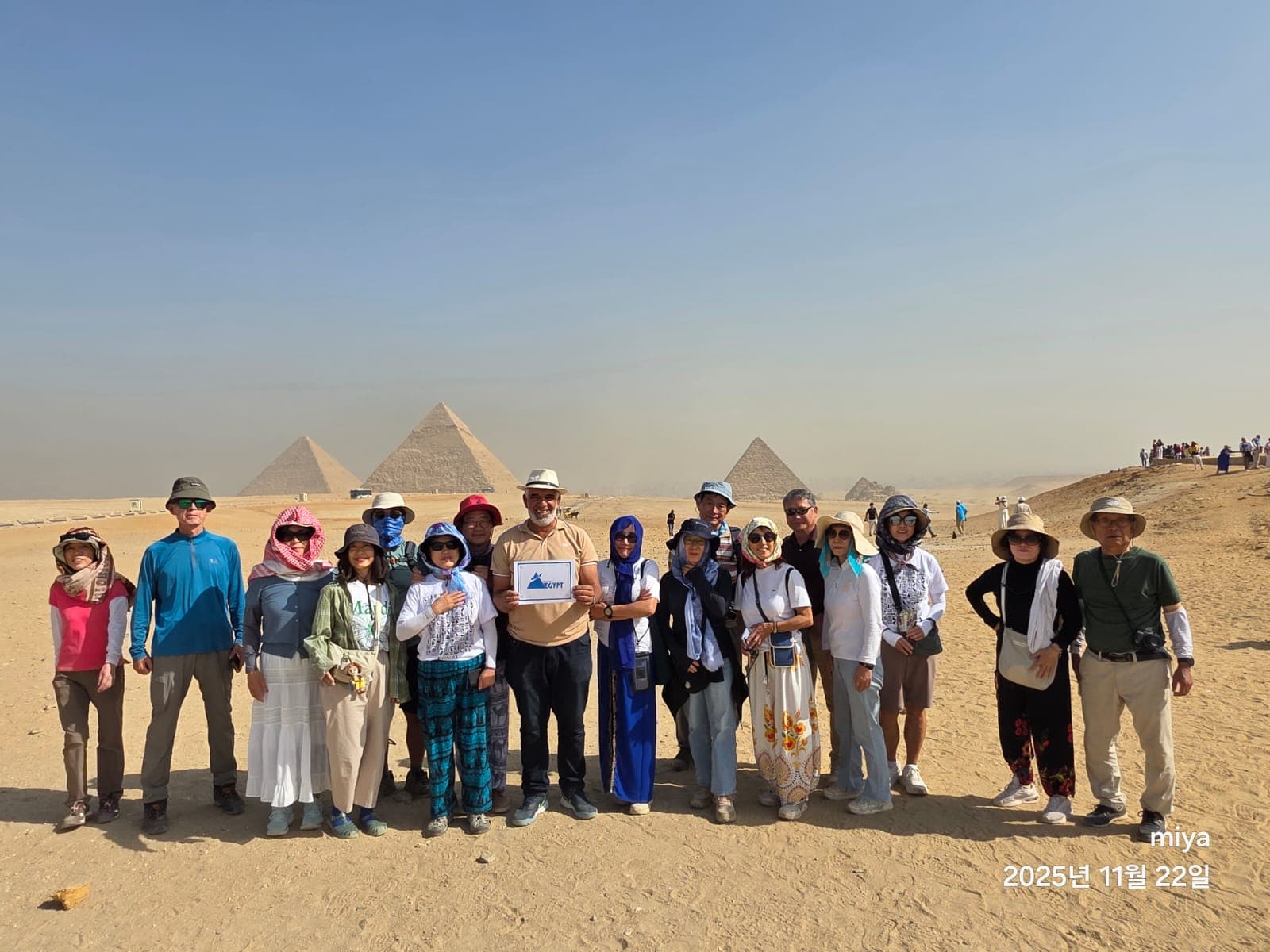 Travel To Egypt guests and their guide in front of the three Giza pyramids